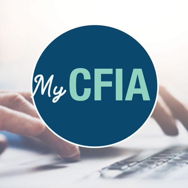 Two hands are typing on a laptop that is displaying the My CFIA sign up page.